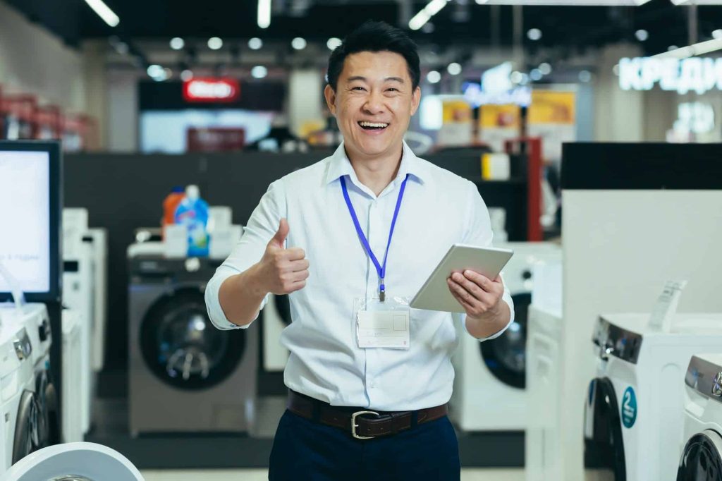successful sales consultant in electronics supermarket asian man working appliances store smiling
